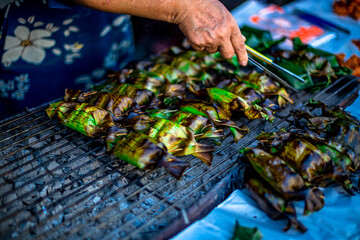 The backdrop of cooking smoke, illuminated by the beautiful morning sunlight, evokes the aroma of...