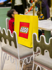 Fototapeta premium Customers carrying the iconic yellow and red themed LEGO bag from India's first store in ambience mall showing the popularity of this toy