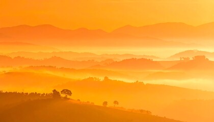 Obraz premium A landscape featuring hazy, layered hills and mountains cast in a golden, warm light