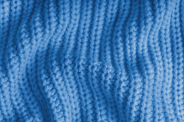 Close up, macro of crumpled blue knitted fabric with visible wrinkles, folds and soft waves. Soft wool texture with detailed stitches and creases, natural textile background, fashion, design © katyamaximenko
