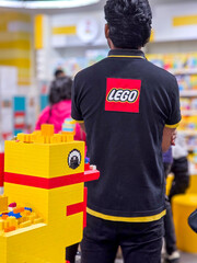 Fototapeta premium Lego store staff member wearing the themed shirt looking at the rush of customers in Delhi's first LEGO store during the opening days