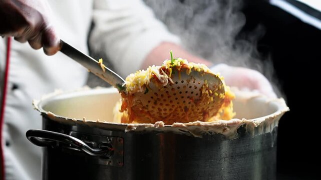 A skilled chef in white attire cooking Biriyani in a restaurant. Spicy chicken biryani with basmati rice, indian cuisine served in traditional restaurant. 4K