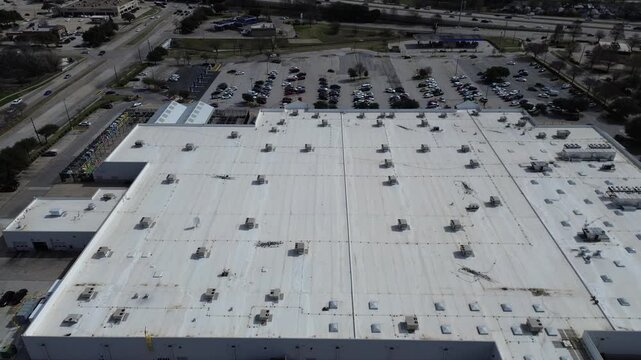 Expansive white industrial roof at large grocery store by busy US 75 highway shows mechanical clusters, HVAC RTU units, parking activity, garden center retailers near Spring Creek Pkwy, Plano, TX