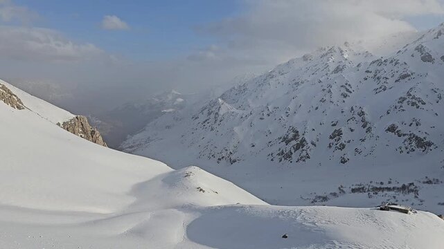 Snow-covered mountain slopes, soft winter hills, and a gentle valley beneath towering peaks under a partly cloudy sky, showcasing serene and untouched alpine beauty.
📍Hawraman Takht, Kurdistan 
