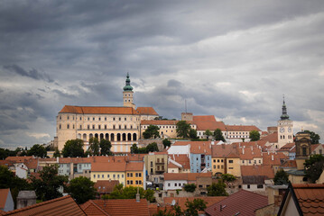 Fototapeta premium Breathtaking panoramic view of the majestic Mikulov Castle and historical town center situated under a dramatic cloudy sky in South Moravia region