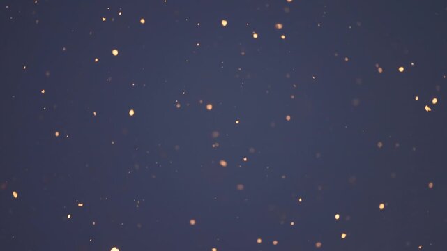 Heavy snow begins to fall under night lamps creating bright illuminated flakes against deep blue sky Atmospheric winter weather concept with visible precipitation in evening air and seasonal ambiance.