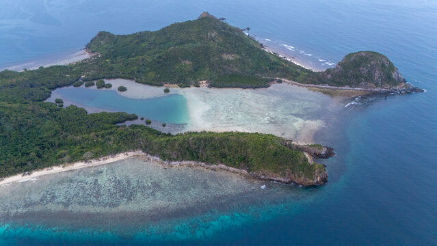 Drone aerial view of Bayang Basecamp or Calibangbangan Camp and turquoise reef along Calibangbangan Island coastline between Coron and El Nido, Palawan, Philippines.