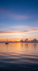 Scenic view of sailboat silhouette on water at sunset with colorful sky, representing tranquility, adventure, and maritime journey