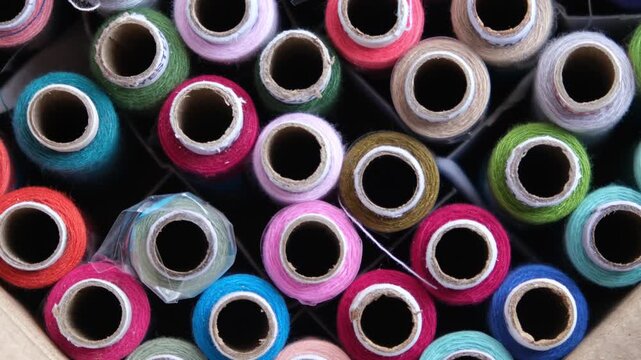 Macro top view of colorful polyester sewing thread spools organized together