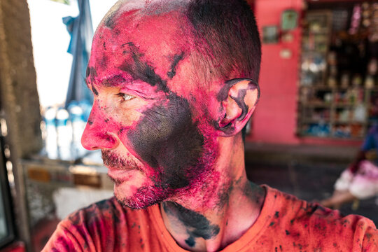 Intimate portrait of traveler with Holi pigment detail