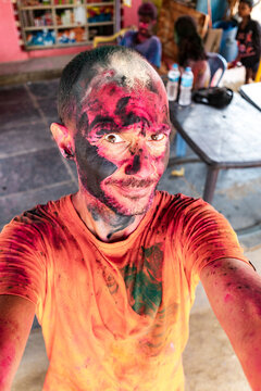Playful traveler making funny Holi face close up