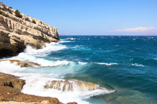 St&uuml;rmische Wellen an der Felsk&uuml;ste von Matala auf Kreta mit blauem Meer und Sandsteinfelsen