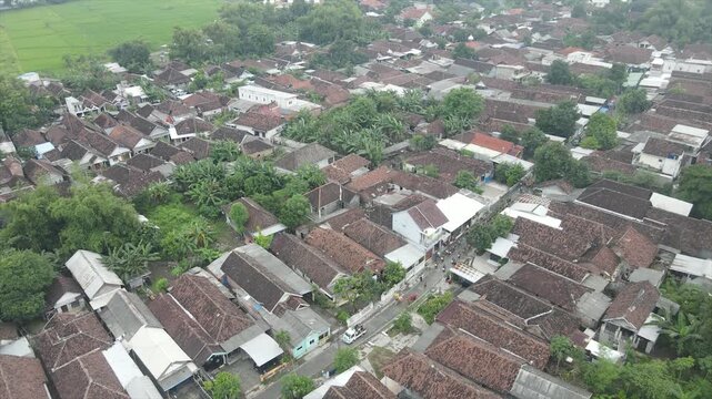 Aerial 4K view of a densely populated rural village surrounded by lush green trees in Indonesia