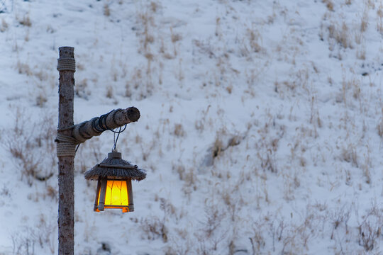Warm Lantern and Large Moon Installation in a Wintry Garden at Night