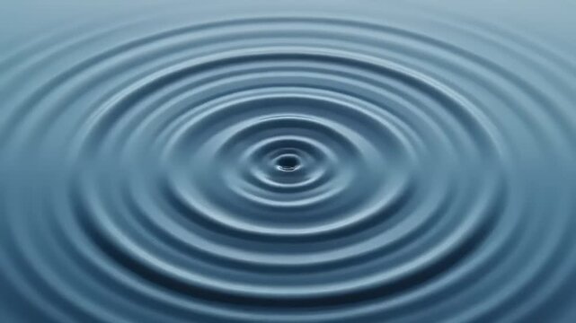 Close up of water ripples expanding outwards from a central drop.