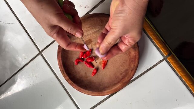 Sambal bawang in the making using traditional tool called ulekan. Sambal bawang is a delicious traditional sauce from Indonesia made from chilies and garlic.
