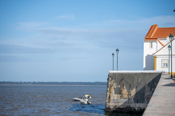 White waterfront building and boats near river wall