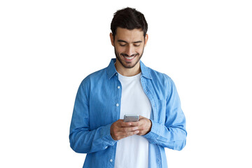 Happy young man in blue denim shirt texting on smartphone while smiling, looking down