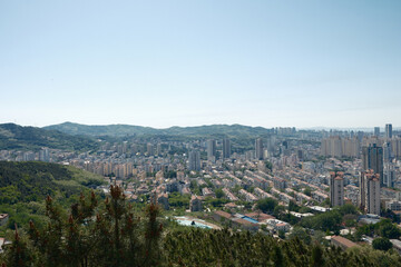 Fototapeta premium Yantai Zhifu District Cityscape with Mountains and Urban Skyline