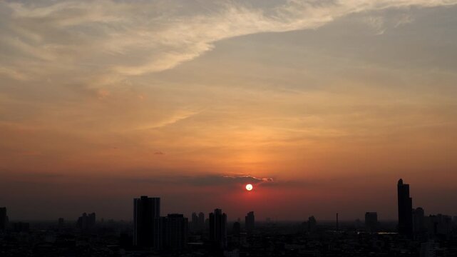 The sun slowly descends as warm evening light spreads across Bangkok city