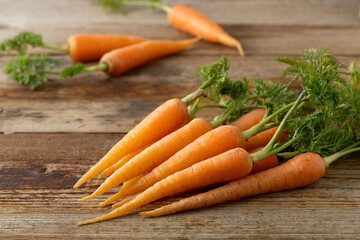 新鮮な葉付きにんじん(木目背景)