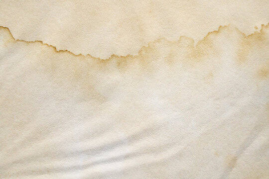Old vintage paper texture background with aged stains and antique yellowed parchment effect