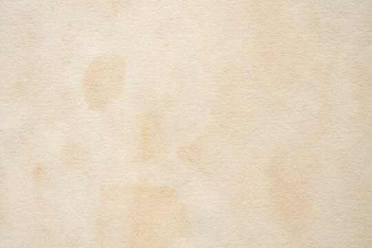 Old vintage paper texture background with aged stains and antique yellowed parchment effect