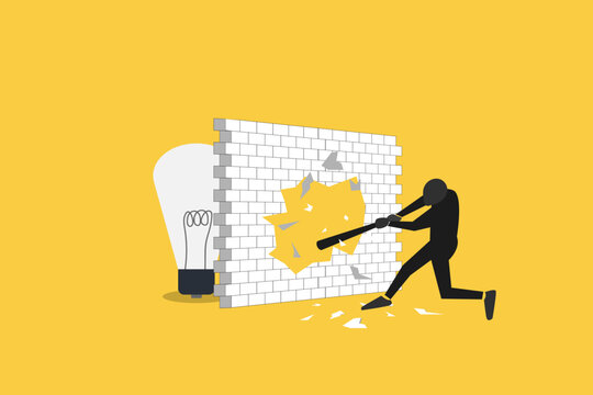 Businessman breaks through a wall barrier with a hammer to discover a bright lightbulb, symbolizing innovation and breakthrough