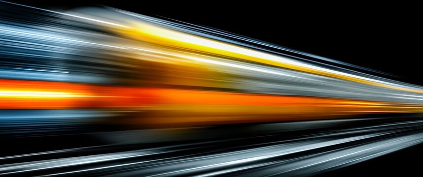 Blurry image of a train with orange and blue stripes. The train appears to be moving quickly