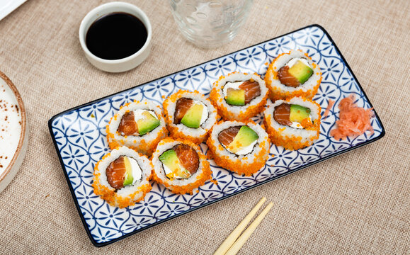 Japanese california roll masago caviar with salmon, avocado and cheese with soy sauce