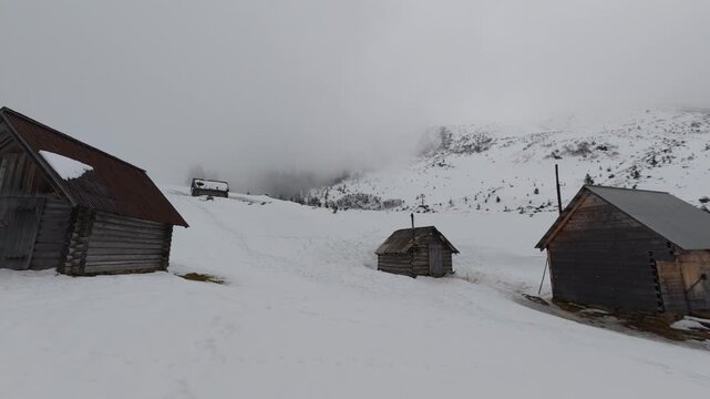 Rustic Abandoned Cabins in Snowy Mountain Landscape