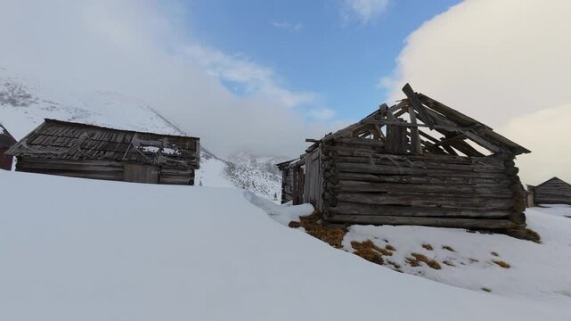 Rustic Abandoned Cabins in Snowy Mountain Landscape
