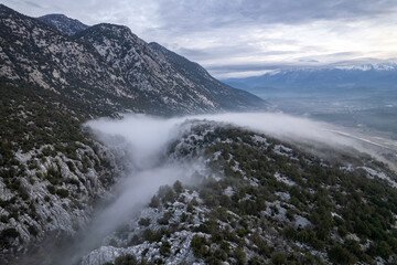 A stunning drone perspective of &Ccedil;altepe village on the St Paul Trail, showcasing the harmony between traditional rural life, green agricultural fields, and the dense pine forests covering the rugged s