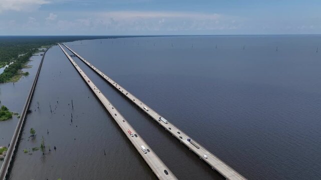 Cars Traveling on raised highway over Louisiana Lake Ponchartrain beside natural wetland bayou at Good Hope, LA