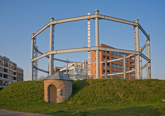 Fototapeta premium Restored old gas storage tank in a newly made park with modern apartment buildings on the Tondelier site in the city of Ghent, Belgium 