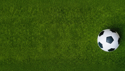 A pristine white and black soccer ball rests centrally on a vibrant green grass field