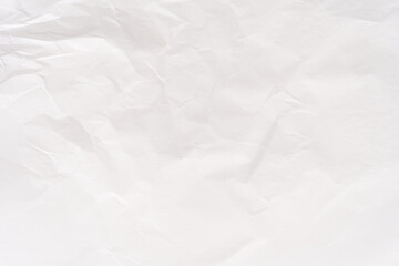 Obraz premium Crumpled white paper texture with soft shadows for design and creative background projects.