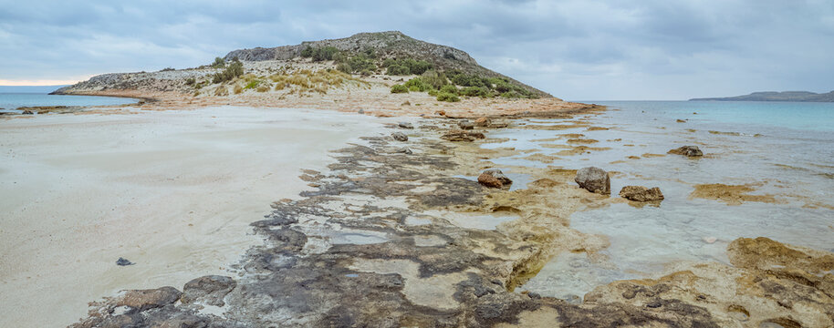 Simos Beach, Elafonisos, Greece: Rocky coastline with sandy beach and calm sea