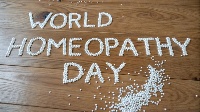 World Homeopathy Day celebration with homeopathic pellets on wood