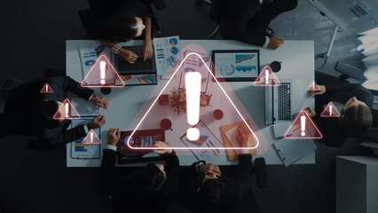 A professional team engages in a strategic meeting with warning symbols, emphasizing critical...