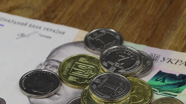 Close-up of Ukrainian coins on a 500 hryvnia banknote, highlighting national currency and financial themes.