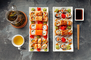 Japanese sushi rolls assortment with salmon crab sesame nori and wasabi served on white plates with soy sauce © Hihitetlin