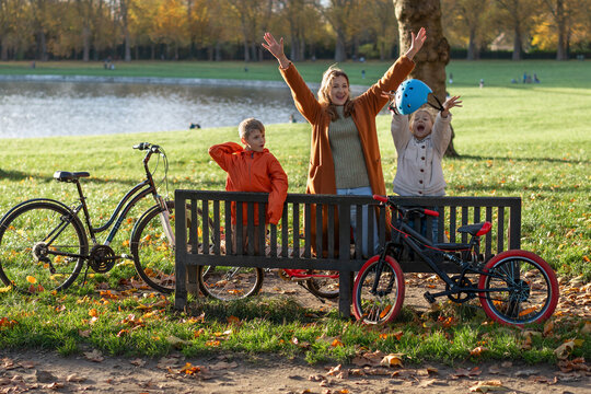 Happy family celebrating bike ride in sunny autumn park lakeside. Lake Swiss or Piece Eau des Suisses