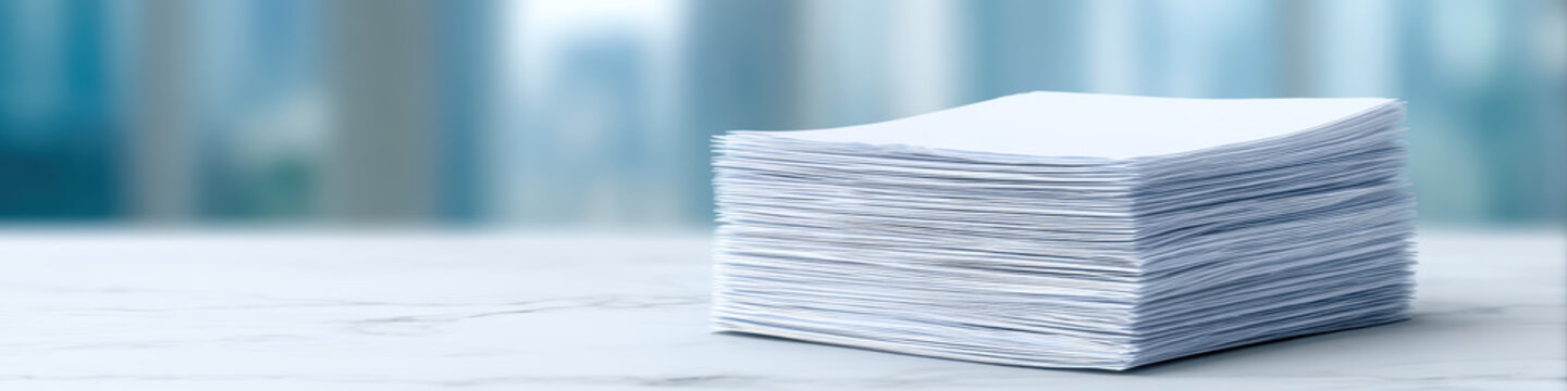 Stack of white documents is neatly arranged on marble surface, showcasing minimalistic style. blurred background adds professional touch, enhancing editorial feel of image