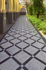 Naklejka premium Side passageway with black-white tiled floor between the south hallway and the central gardens of the Moulay Ali Cherif mausoleum. Rissani-Morocco-148