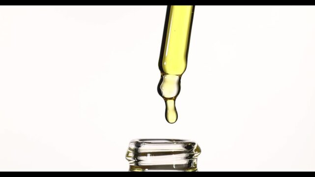 4K slow motion hand pulling pipette from glass bottle, golden cosmetic oil dripping and flowing back, dropper returning into bottle, macro beauty serum, studio shot on white background