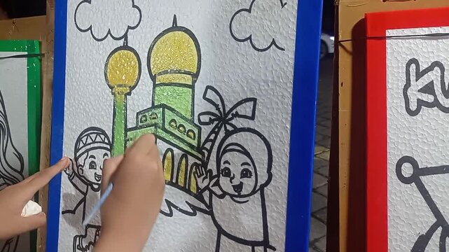 Macro shot of a child's hand painting on styrofoam with vibrant watercolors