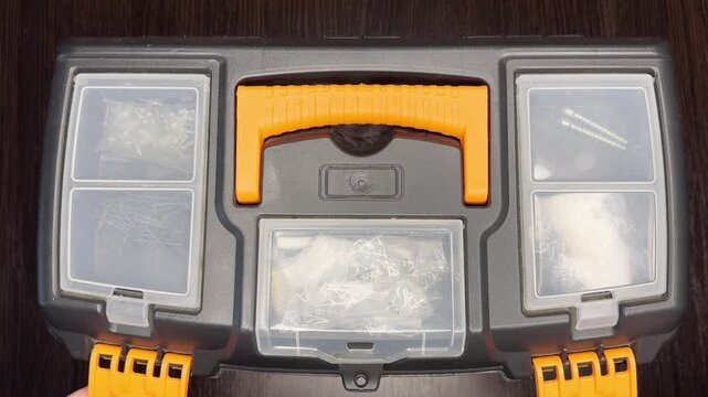 Close-up. Male hands open a toolbox and select the right tool. Perfect video for home repair, DIY, maintenance and workspace organization.