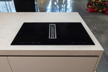 Black induction hob with integrated extractor on kitchen island