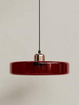 Ruby red modern lamp with glossy glass shade and metallic fixture isolated on neutral background
